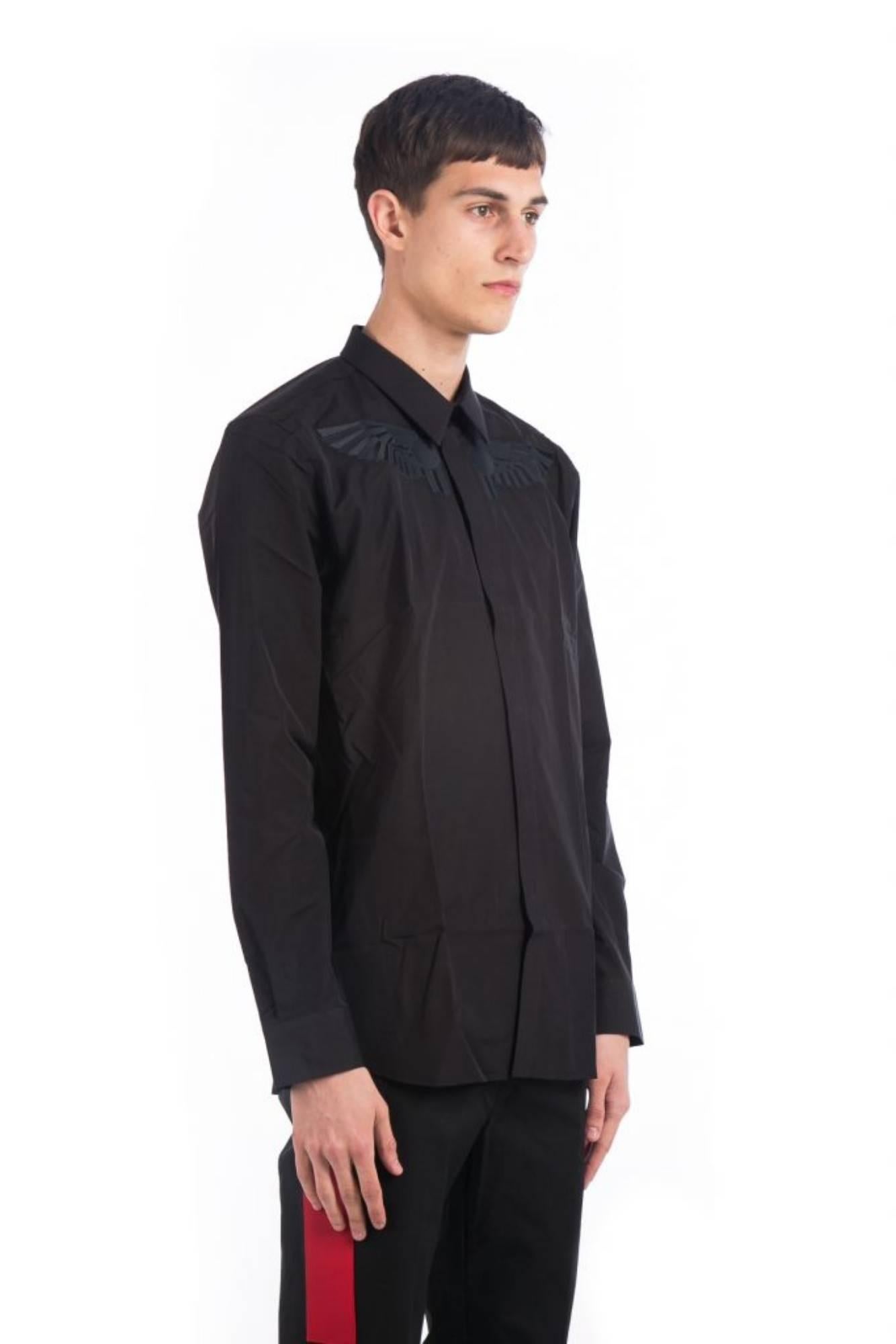 Wing Embroidered Shirt
Black shirt
Embroidered wing detail on chest
Classic collar
Concealed front button placket
Long sleeves
Single button cuffs
Curved hemline
Composition 100% cotton