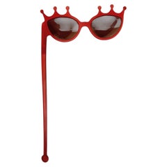 Corinne Cobson X Alain Mikli – Rote Sonnenbrille aus Kunstharz zum Tragen in der Hand