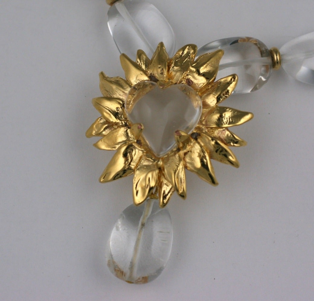 Lovely rock crystal necklace by Robert Goossens, Paris. A large rock crystal heart is set into a gilded bronze sunburst with a rock crystal pendant drop. Large oval rock crystal beads have gilt bronze spacers. Elegant and beautifully made by hand in