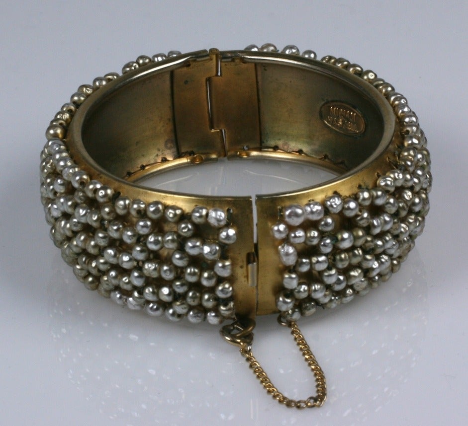 Miriam Haskell pearl lattice  woven  hinged cuff bracelet. Of signature Russian gold gilt metal,and hand woven baroque pearl lattice.

Interior L 6.50"
W 14/16"