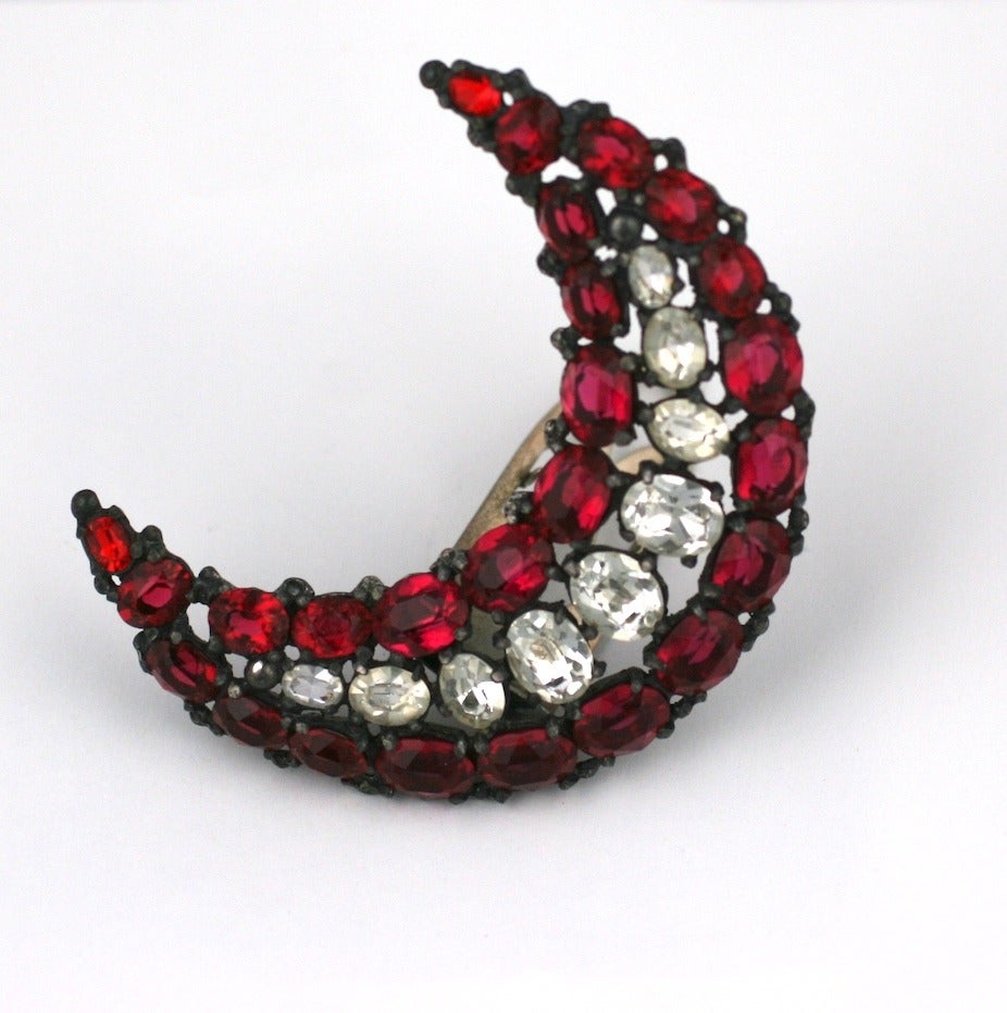 Oversized ruby and faux crystal crescent moon shaped clip by Eisenberg, circa 1930's. Eisenberg began as a dress house ,but, their success with the embellishments and ornaments propelled them into the jewelry business.
Their signature designs were