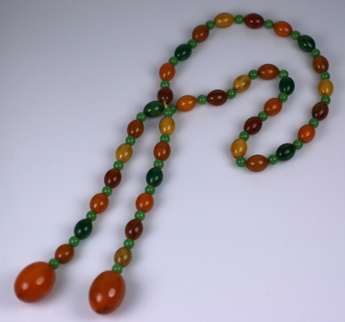 Art Deco Bakelite lariat in tones of green, caramel and amber. Can be worn as a belt as well. Great summer colors made to look like organics. 44