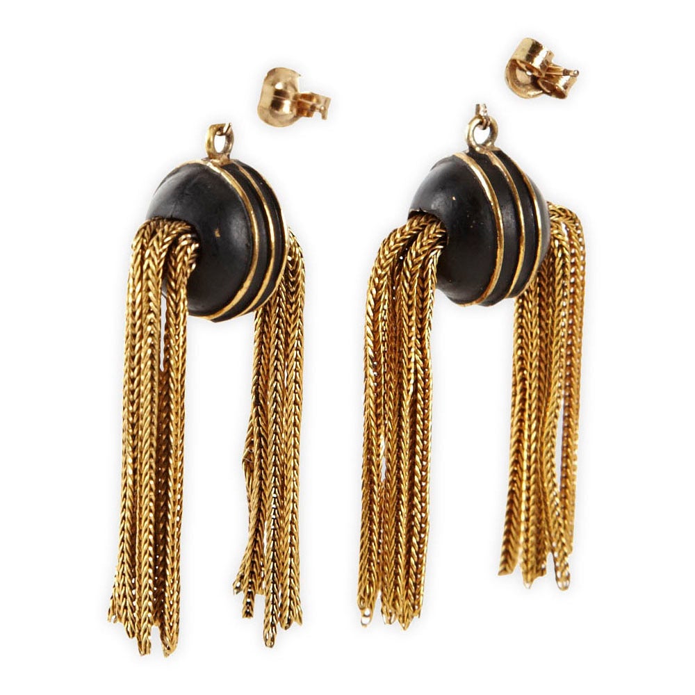 Highly unusual late Victorian earrings reminiscent of golden snitches. A gutta percha sphere is trimmed with gold filled bands with gilt fox chain side tassels. Gilt ball posts with pierced back fittings. Gold filled metal with gutta percha.
1870's