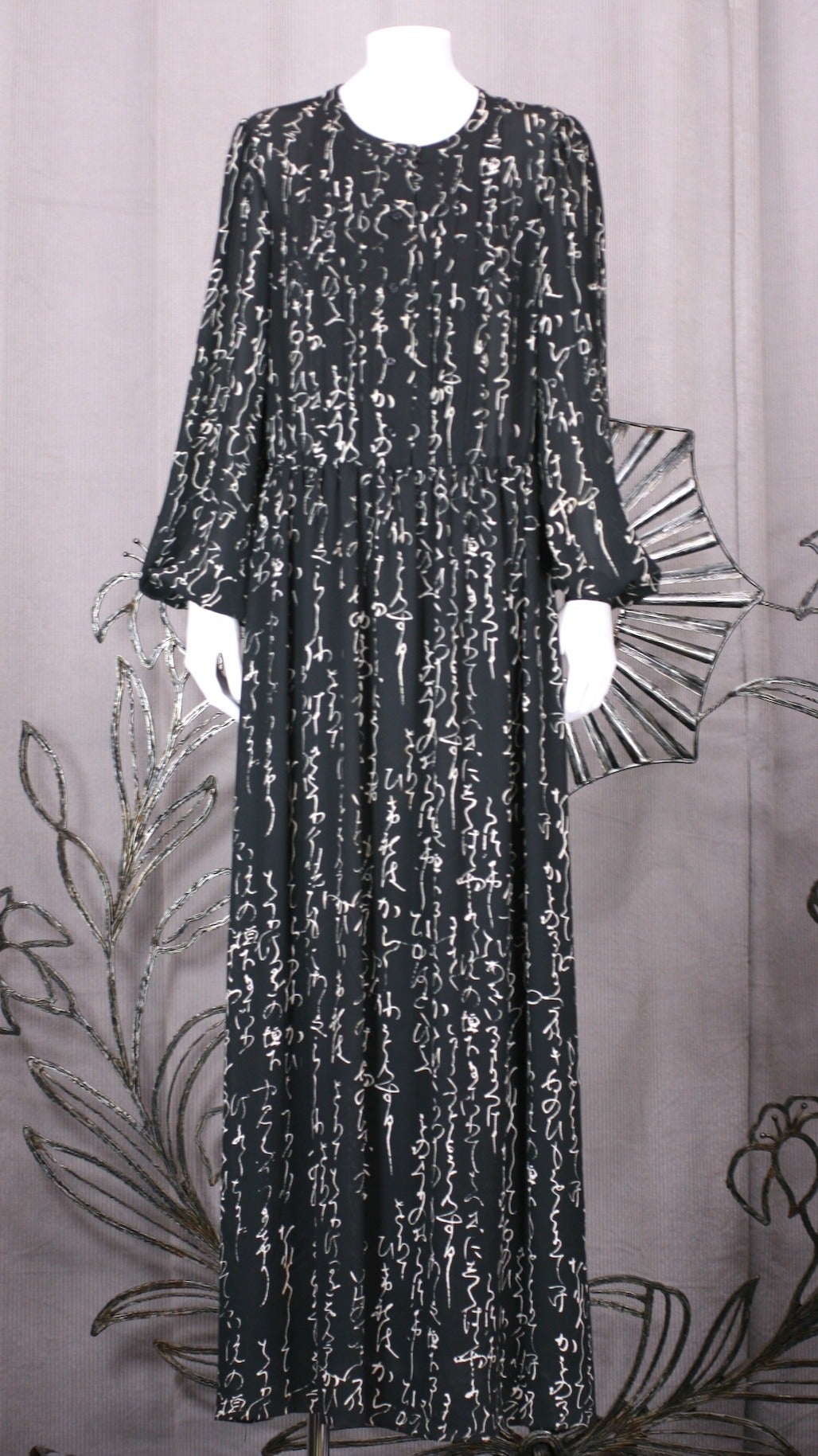 Hanae Mori calligraphic print gown in graphic black and white semi sheer georgette. 
One piece gown with tucked bib and button placket attached to gathered skirt at waist. Easy fit with gently gathered sleeves. Lined in rayon. Japan 1990's.
Belt