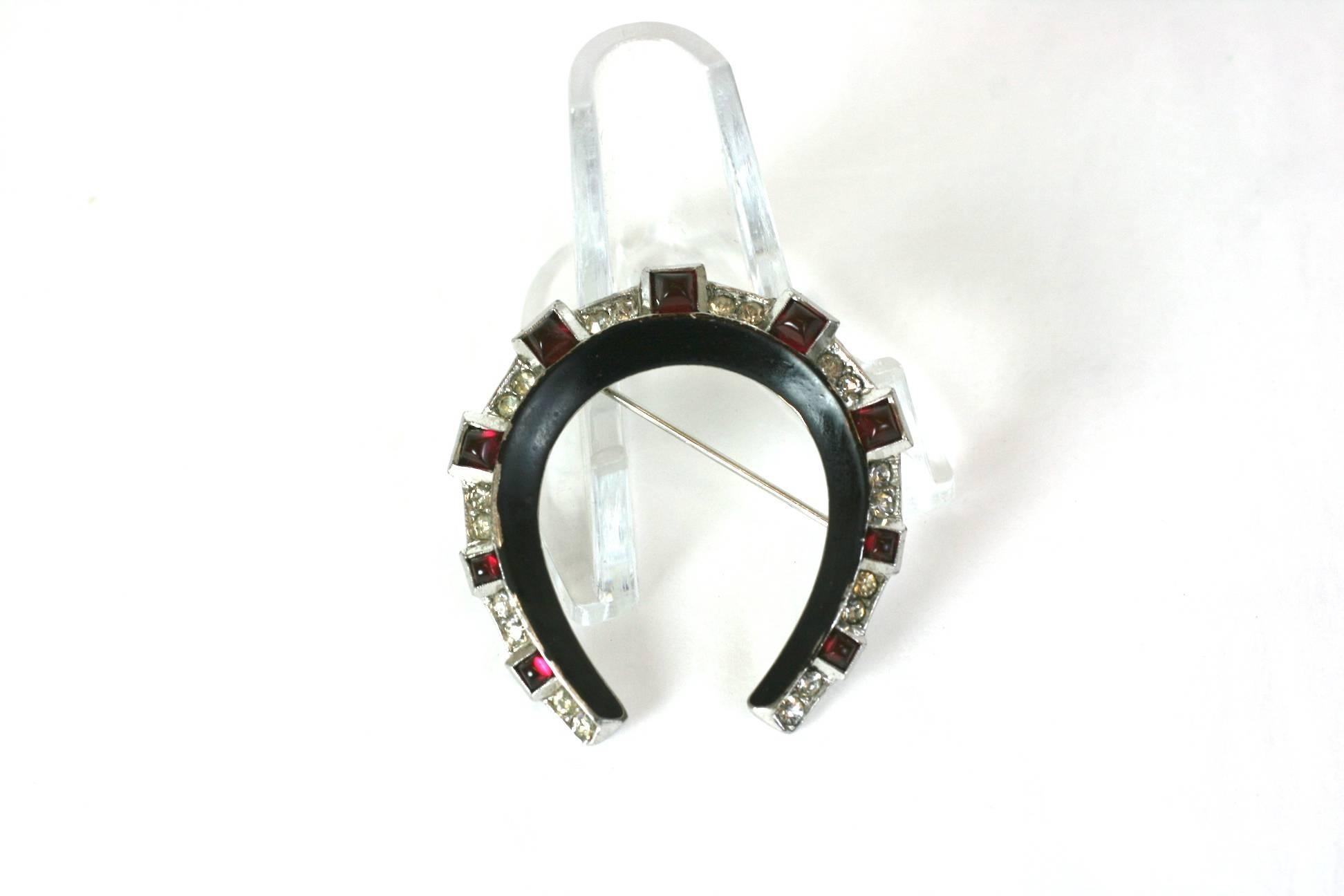 Trifari Art Deco Lucky Horseshoe Brooch. Black cold enamel on a rhodium plated ground highlighted by crystal pave and cabochon square cut faux rubies.
Excellent Condition, 1930's USA.  1.50