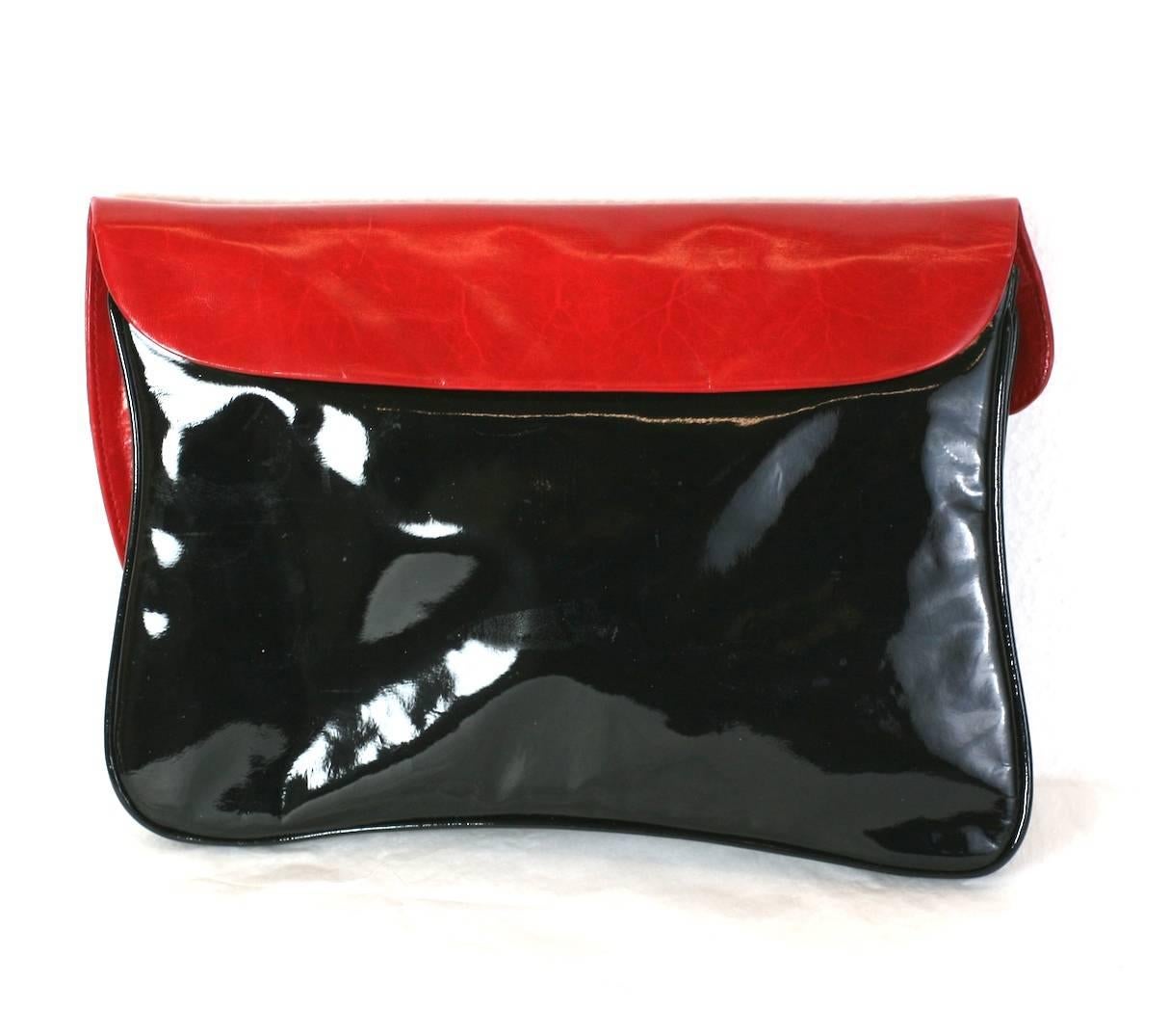 Italian Postmodern Clutch in calf and patent with charming paint drip motif. Red calf leather contrasts nicely against the sleek back patent leather. Long crossbody shoulder strap can be concealed inside. 1980's Italy. Excellent condition. 12