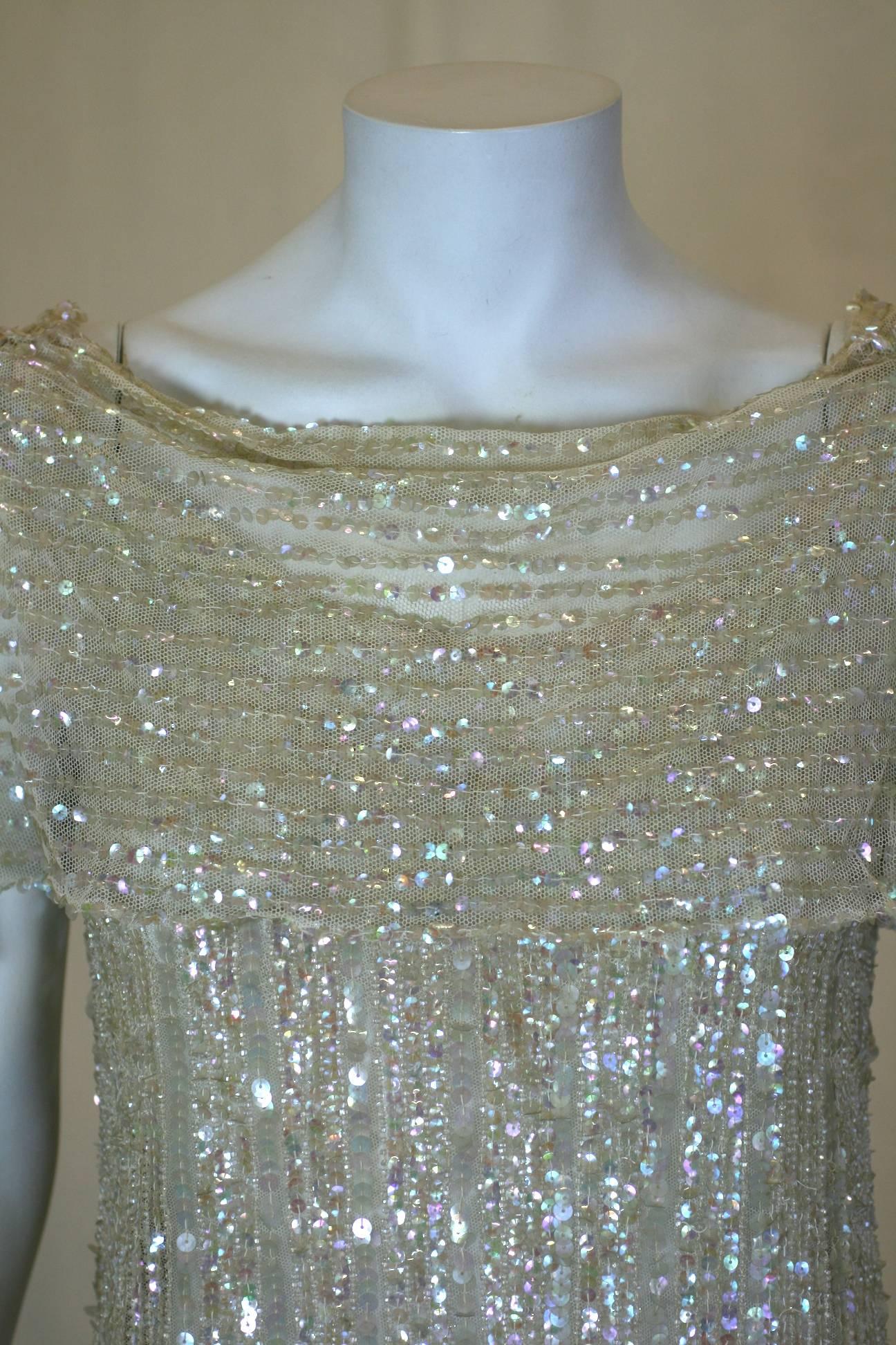 Elegantes und zeitloses Art Deco Kleid aus französischem Paillettenstoff, genäht auf Baumwolltüll. Nackte, schillernde Gelatine-Pailletten bedecken das gesamte Kleid. Oberhalb des Knies befinden sich paillettenbesetzte Art-Déco-Rautenmotive, die
