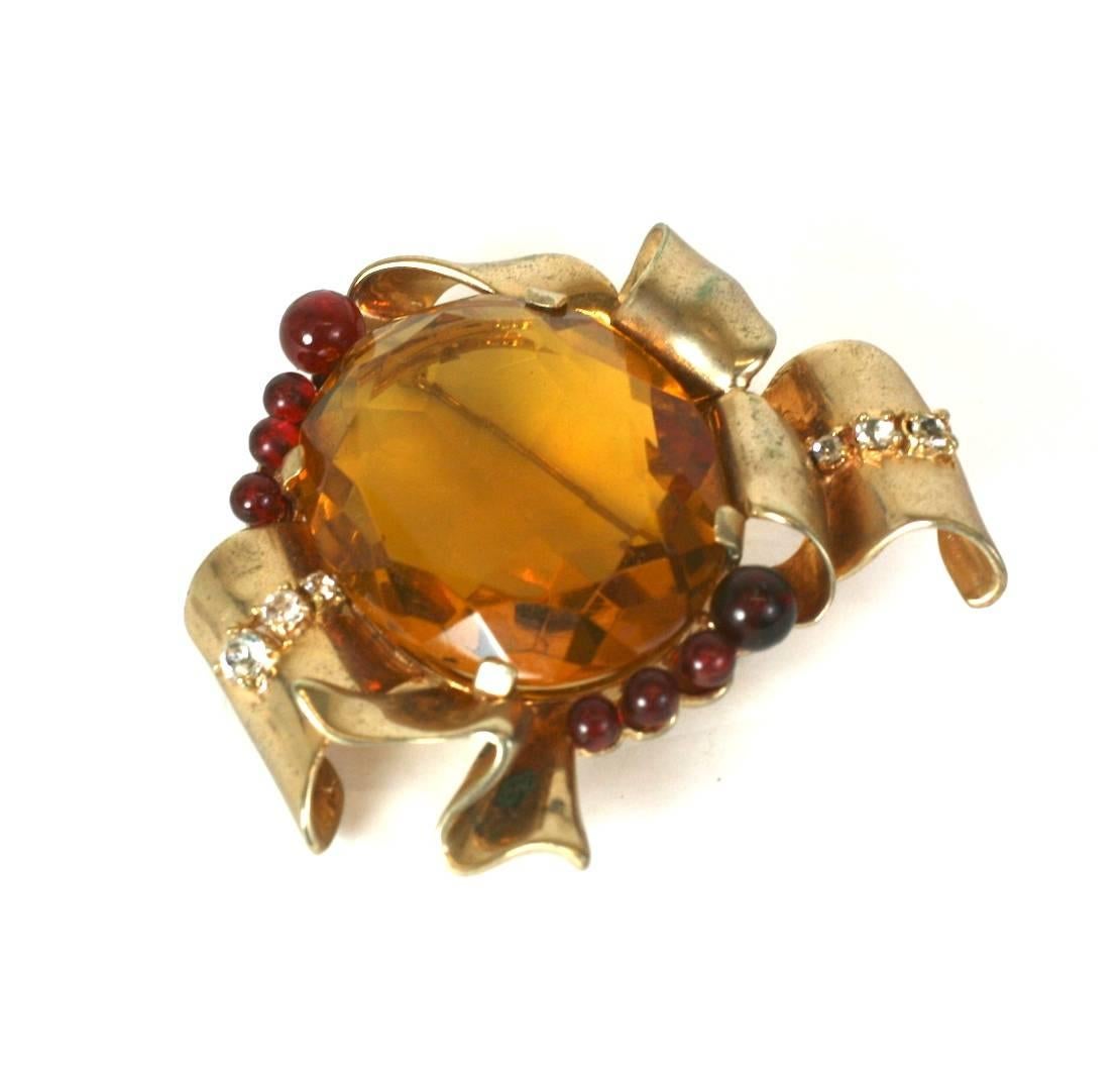 Large, dimensional Ciner Retro brooch of gold washed sterling silver. Large focal, oval faux citrine stone is flanked on both sides by faux ruby beads and crystal pastes. 1940's USA. 
Excellent Condition.