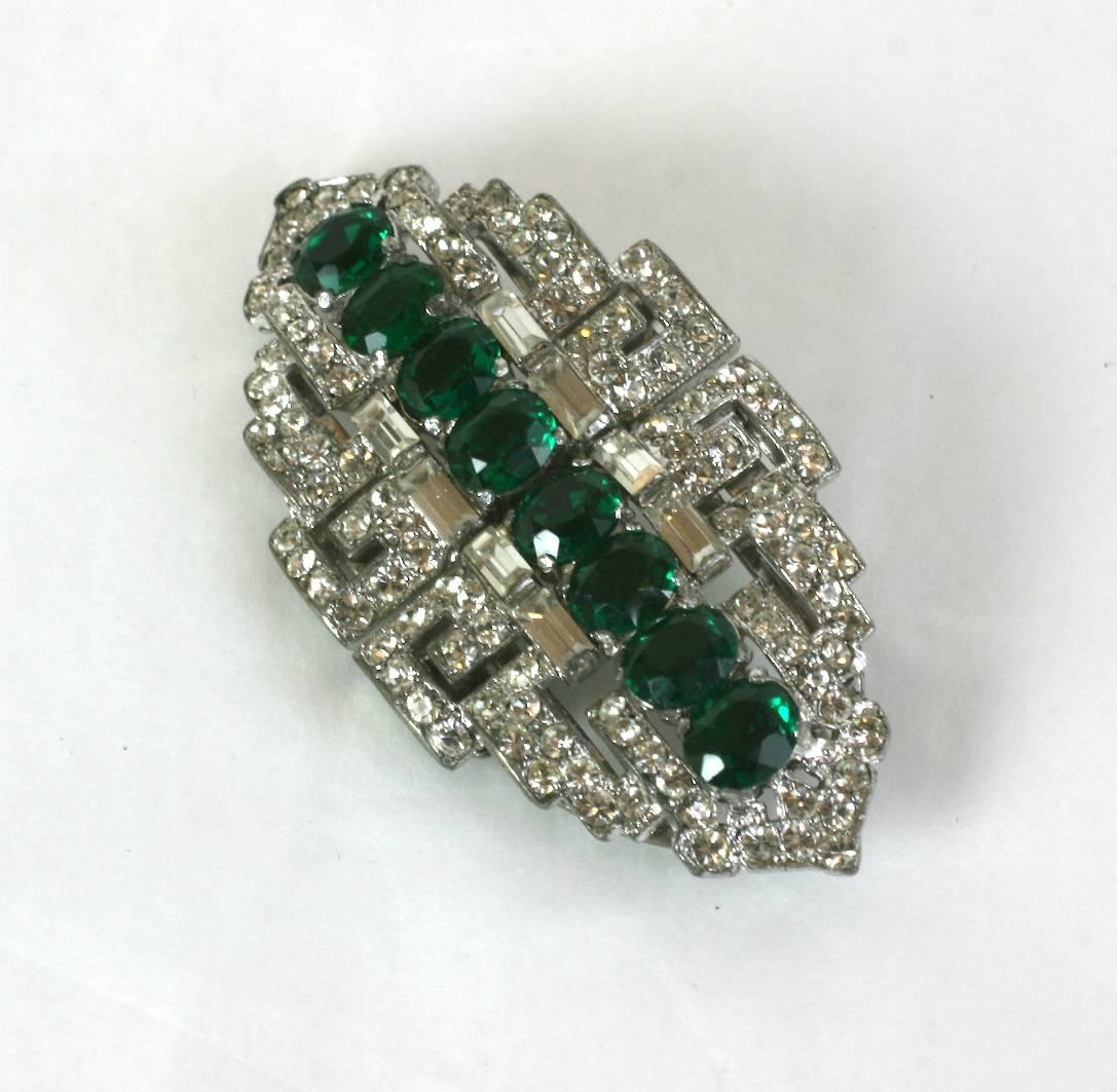 High style Trifari Art Deco Faux Emerald Clips from the 1930's. This pair of versatile Art Deco clips can be attached to a frame which turns them into one brooch, or they can be separated and used on a lapel or garment edge as sparkly decorations.