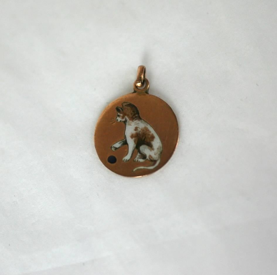 Charming Art Deco Cat Charm from the 1920's. A spotted cat is beautifully enameled playing with a black ball on 9-10 ct gold. 
.50