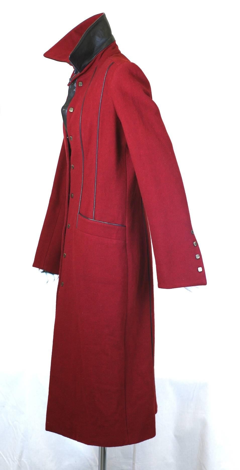 Lou Lou de la Falaise sleek, fitted wool melton coat with wonderful leather trim and detailing. Leather piping along torso and elongated flared sleeve cuffs give this coat a long, lean line.
Black leather is used to contrast the medium weight wine