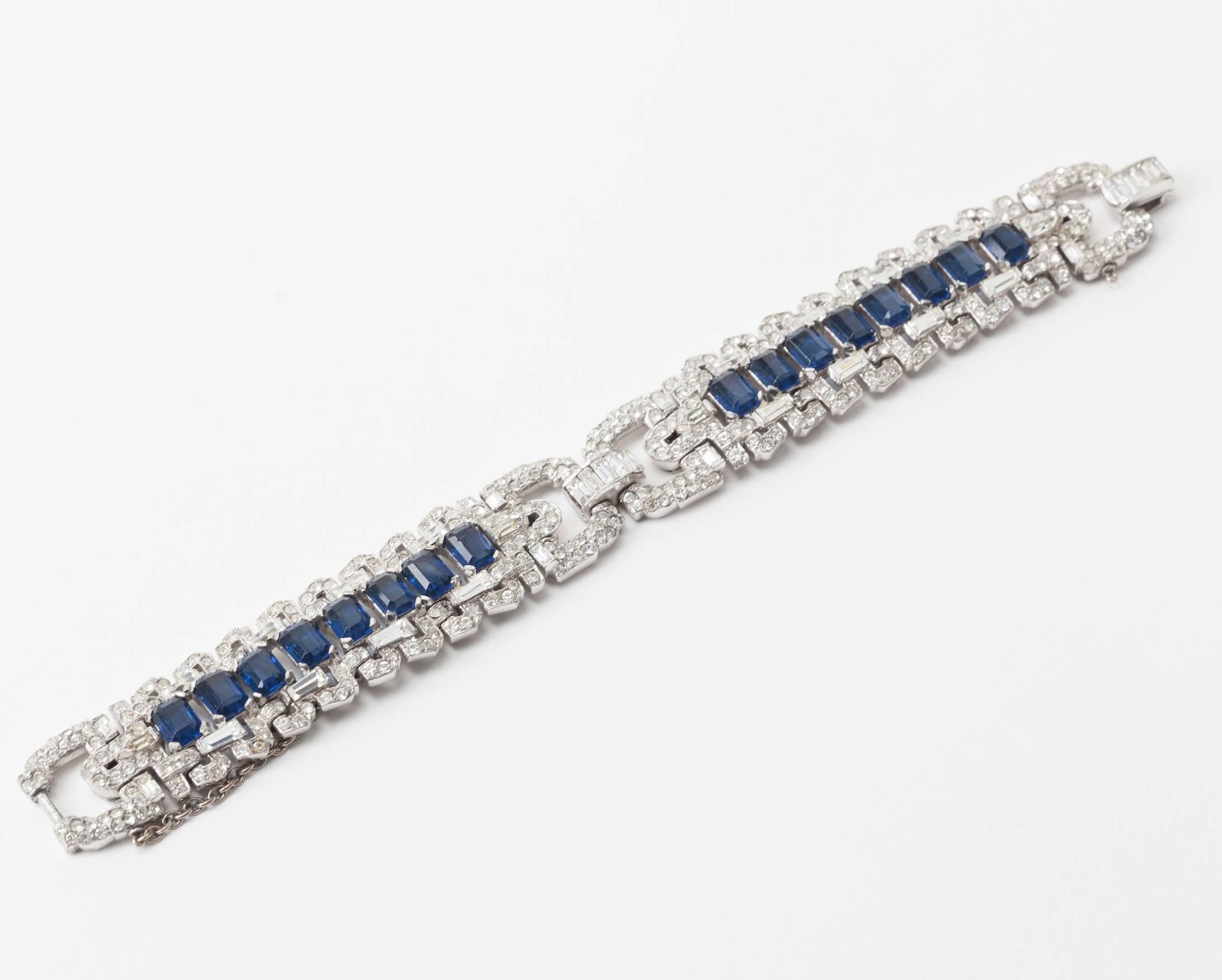 Spectacular Early Trifari Art Deco Bracelet from the 1930's in the high Art Deco taste. Beautiful quality designed likely by Alfred Phillipe for Trifari. Tight pave work with a row a central row of emerald cut faux sapphires. High rhodium finish.