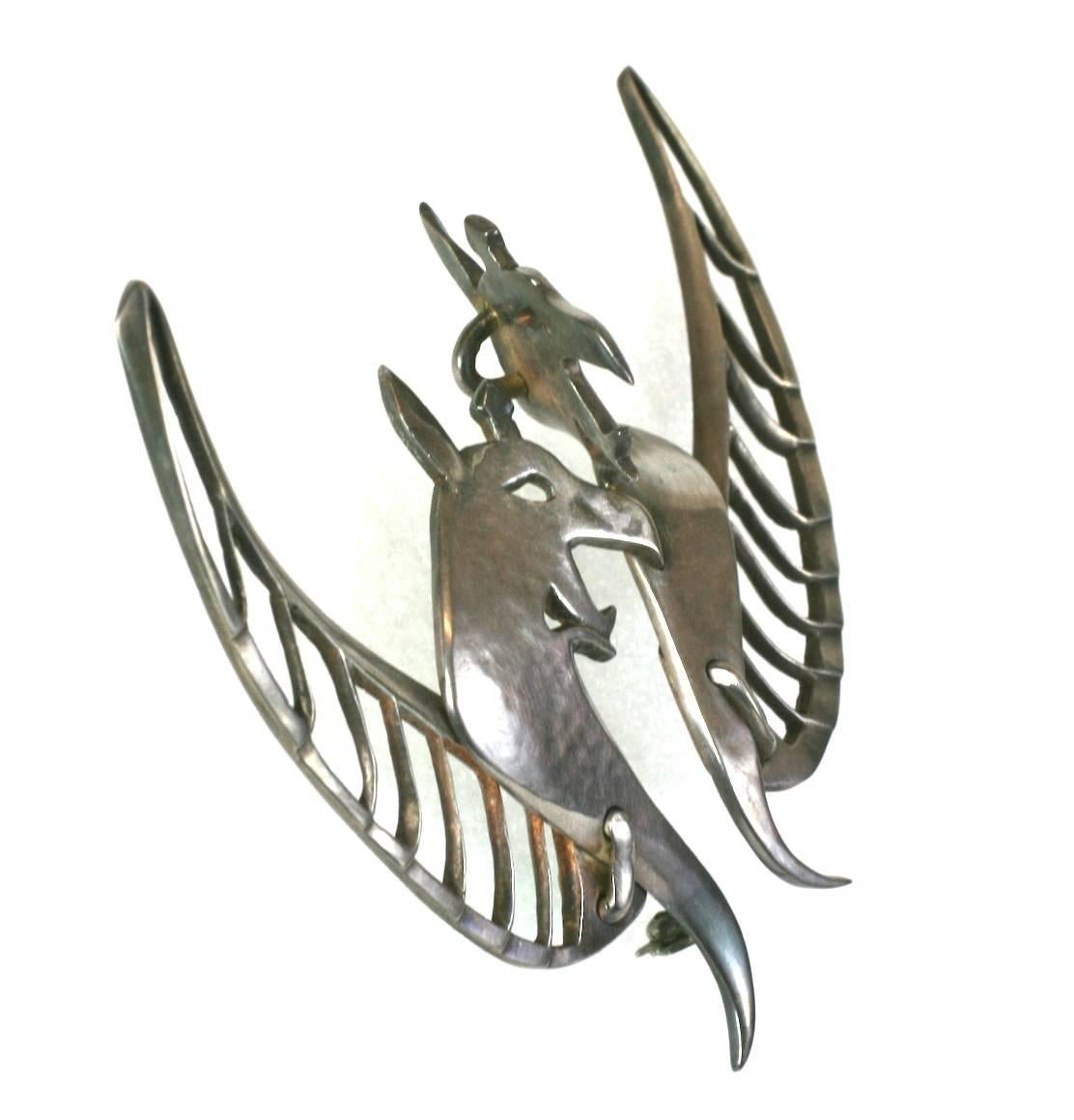 Unusual Artisan hand crafted double Gargoyle Modernist brooch from the 1980's with pendant attachment for use on a necklace.
Large and striking, with both pierced and hammered sterling silver elements which create dimension on this hand made piece.