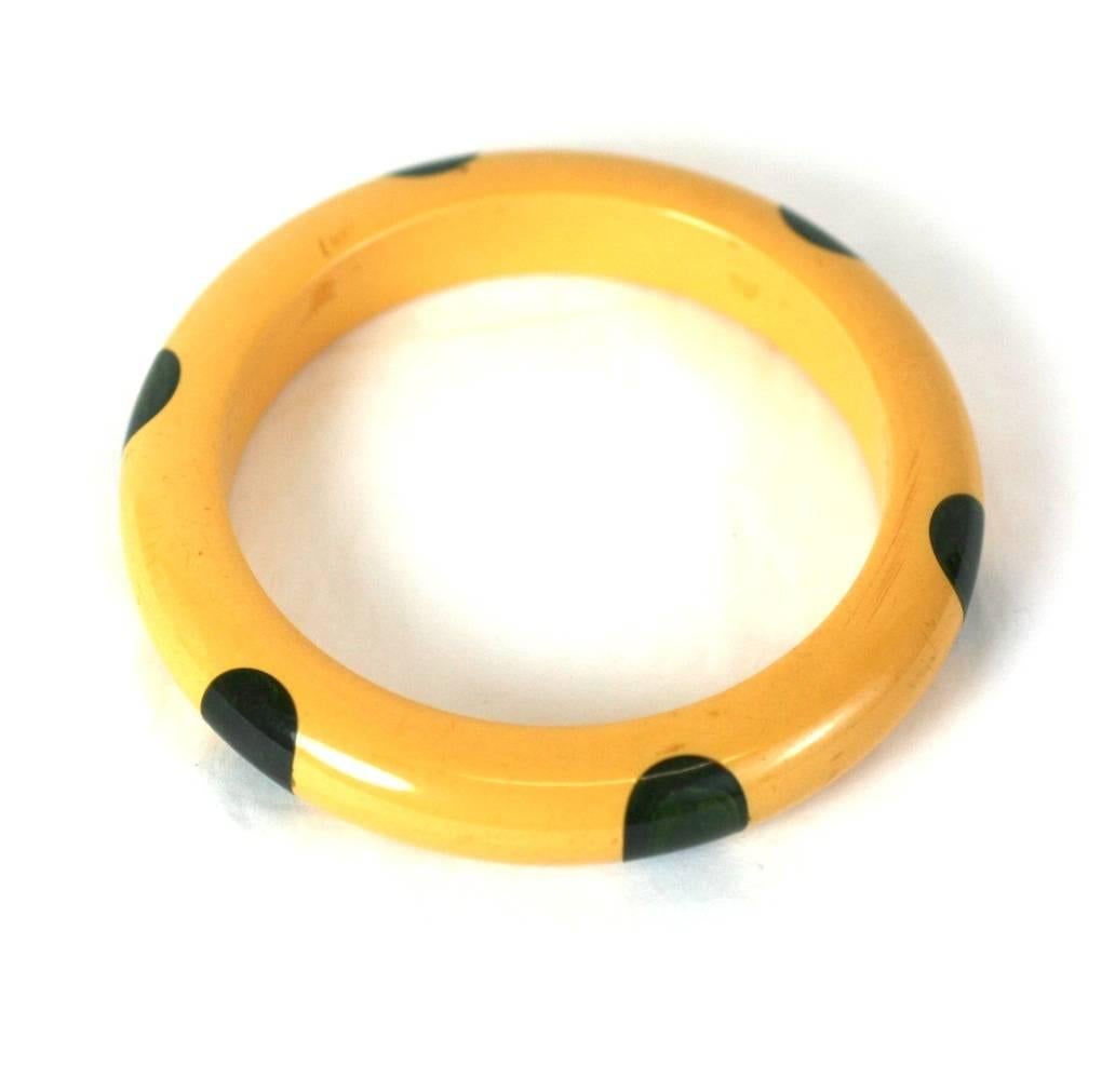 Bakelite Gum Drop Bangle from the 1930's. 6 deep marbleized blue dots are injection molded into creamy yellow bakelite. Collectible bracelet from the Art Deco era. Excellent condition. 
.5