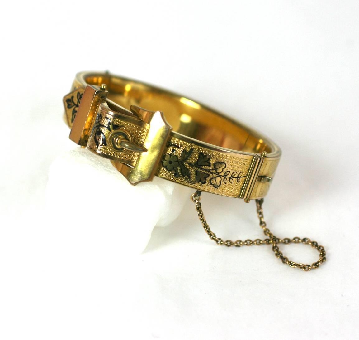 Attractive Victorian gold filled bangle with buckle motif and black enamel floral tracery. Engraved designs on obverse. Pull clasp with attached safety chain.
1880's USA. (dated 1880 on clasp!). Excellent condition. 
Bangle is .5