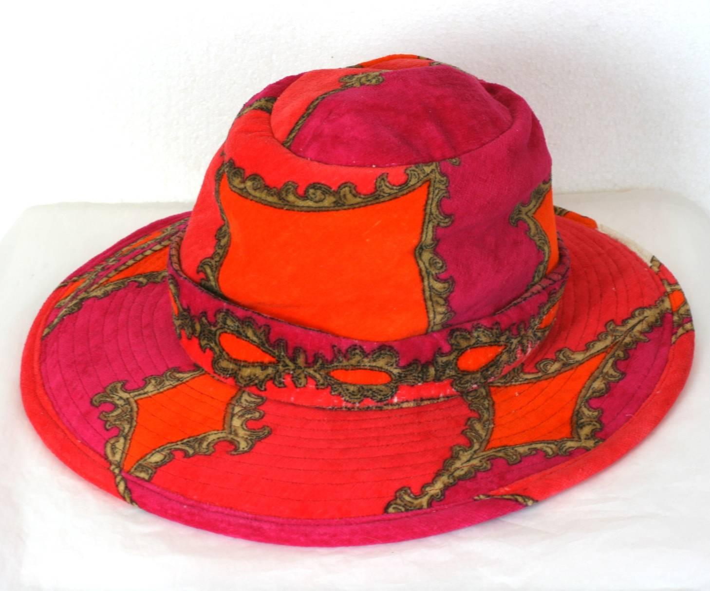 Very cool Pucci style terrycloth Hat made in the 60's Italy. Trapunto top stitching on brim with self belt decoration at base of crown. Gilt baroque patterns on brightly colored cotton base. Italy 1960's. Excellent condition. 
Crown 3.5