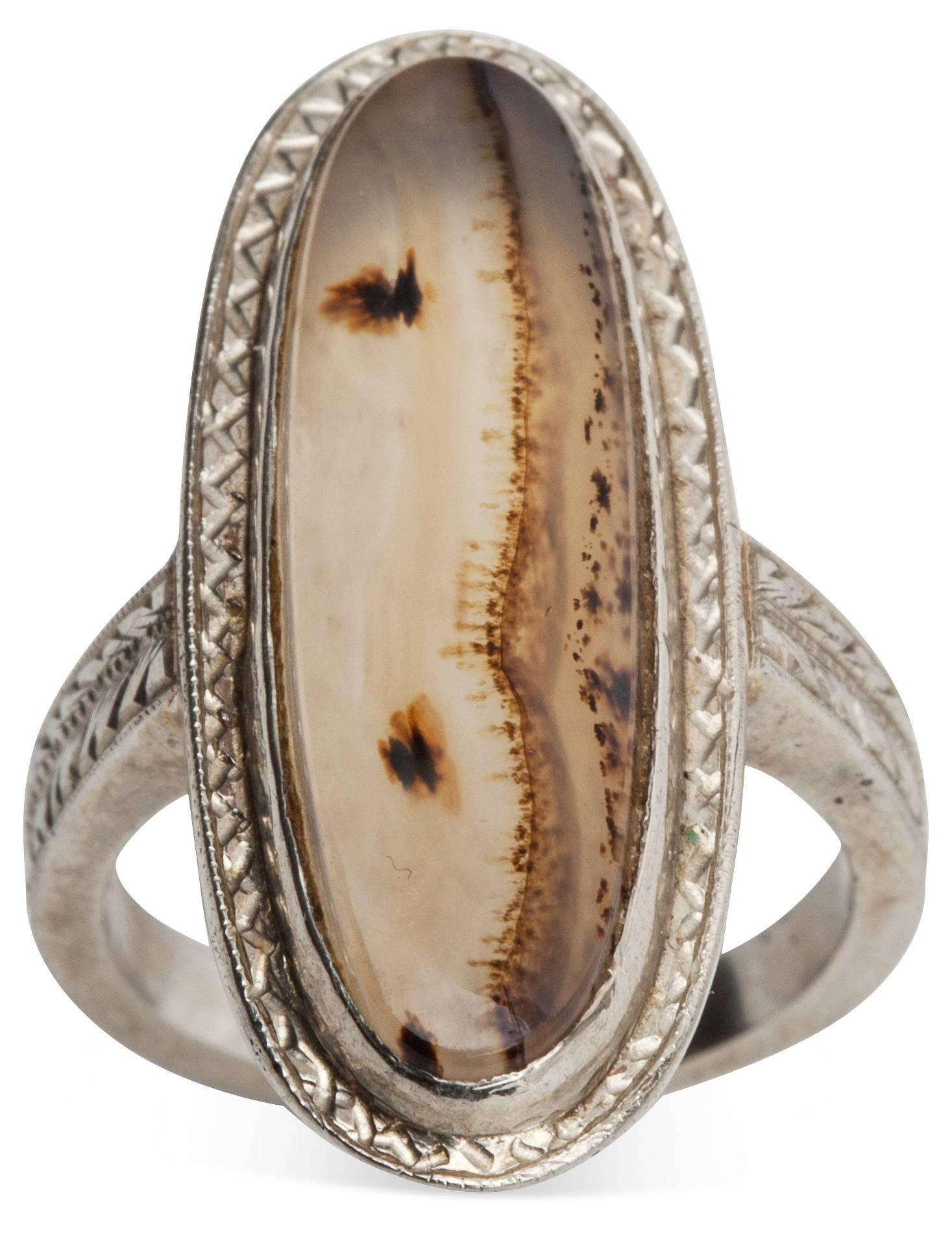 1930's Art Deco 14K white gold engraved ring with landscape agate stone. Attractive configuration running up the finger. Nicely detailed engraving on shank and shoulders. 1930's USA.
Size: 5.