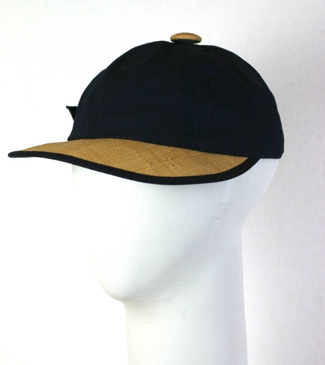 Charming 1950's raffia and navy seersucker cap by Kathleen Originals of Miami.
Beach wear fashions of the 50's used unusual materials such as seersucker and raffia for both fashion and sun protection purposes.
Crown 3.5