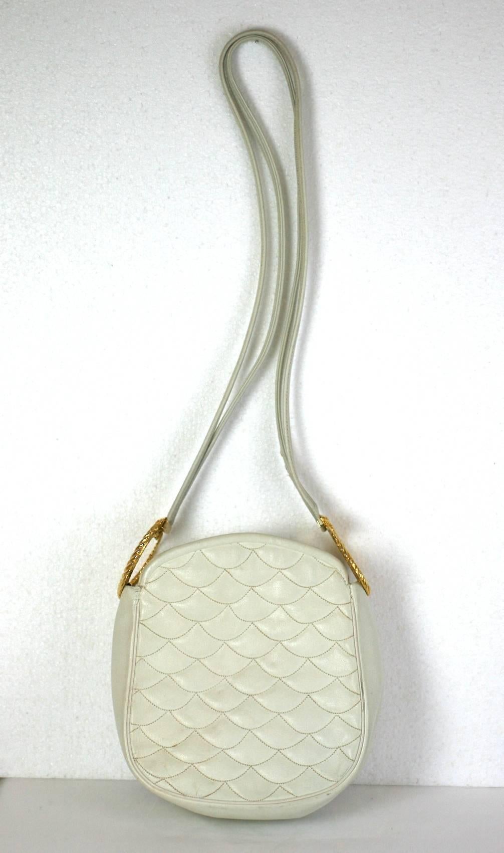 Harry Rosenfeld ivory leather shoulder bag with swirled gilt lion hilts suspending long shoulder straps. Ivory leather is wave quilted on body. An attached coin purse is on the interior. Dated 1972, Harry Rosenfeld.  Body 7