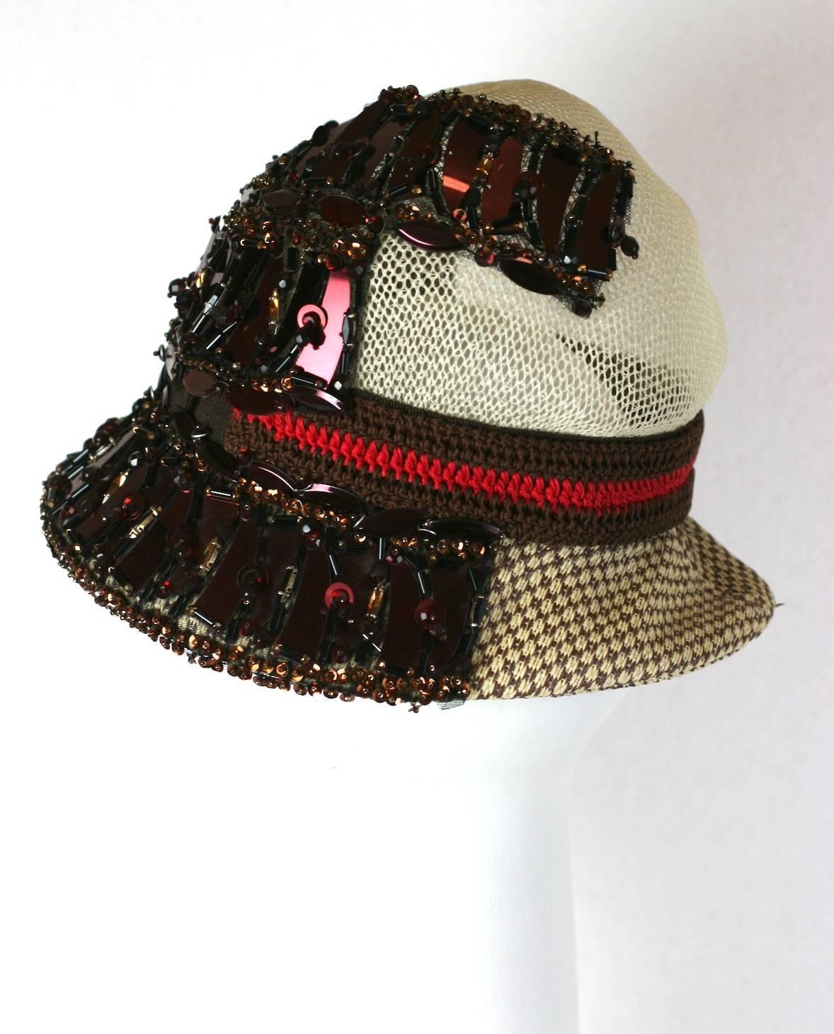 Prada primavera 2005.  Cappello Cloche elaborato da collezione con perline, paillettes, uncinetto e applique, look 55. 
Questo cappello presenta un'incongrua mescolanza di materiali e texture che rendono gli amori di Miuccia Prada completamente