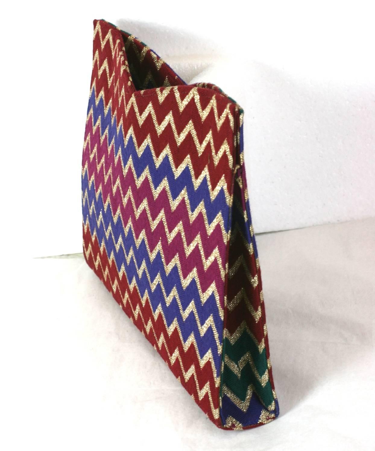 Missoni signature jersey knit clutch bag of gold lurex, burgundy, purple and magenta zig-zags motifs with vivid emerald green sides. Backed on a hard satin base with magnetic closures. 1980's Italy. Excellent Condition.
L 10