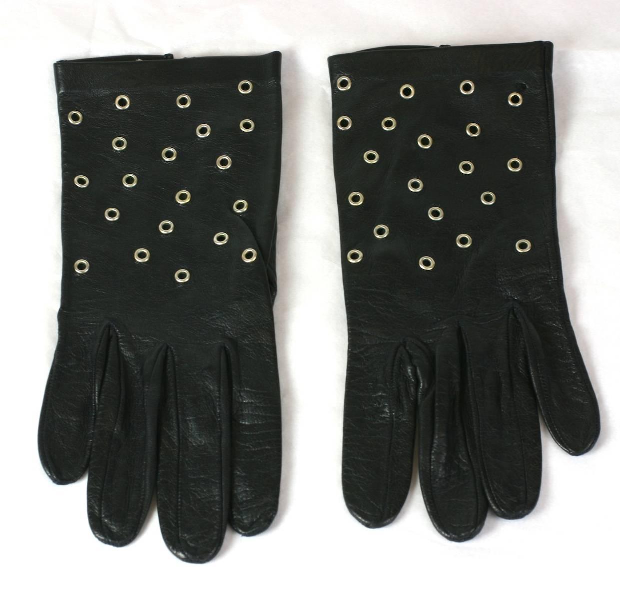 Italian black leather gloves studded with silver metal grommets a la Alaia, 1980's Italy. Size 7. Excellent condition. 
