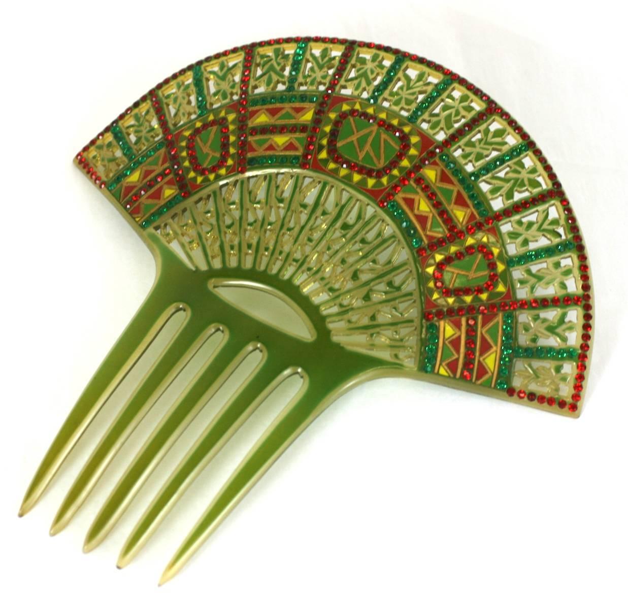 Wonderful Art Deco Eygptian Revival Comb of clear celluloid overlaid with green. The design is then pierced, overpainted and set with pave stones in red and green. France 1930's. 
Excellent condition. 7