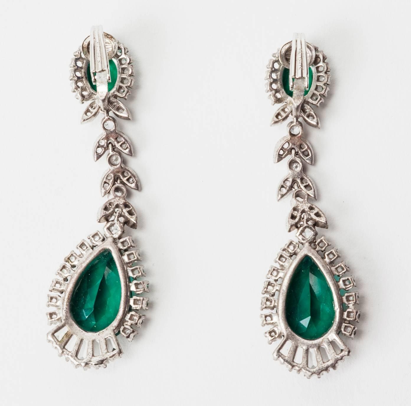 Elegant Faux Emerald Paste Earrings set in sterling silver made to replicate fine jewelry. Beautiful quality, and completely articulated. Striking scale, set with unfoiled crystals in crystal and emerald with tapered baguettes. 1950's USA. Clip back