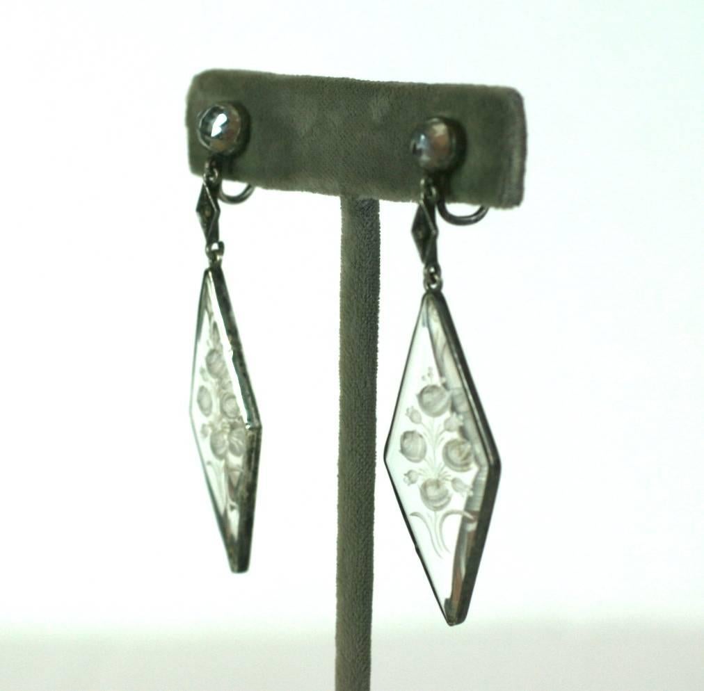 Attractive Art Deco reverse carved crystal and marcasite earrings set in sterling silver. Floral bouquets are etched into crystal drops and rose cut cabochons are used on the ear. A single marcasite is set in a connecting link. Screw back fittings.