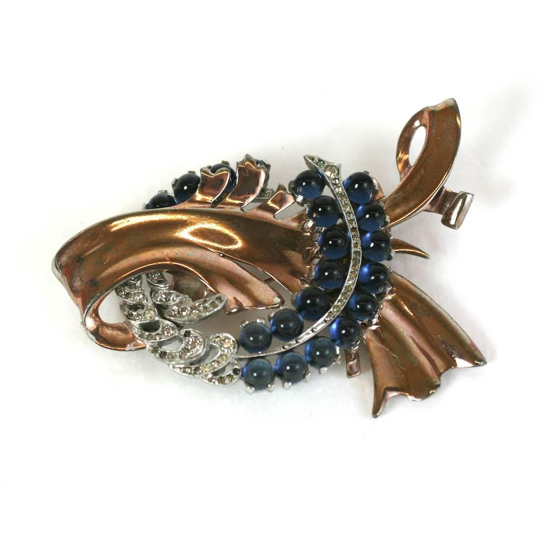 Wonderful, dimensional faux sapphire retro swirl brooch from the 1940's. A swirl of rose gold plated metal is accented with a pave set and faux sapphire cabochon interlocking 