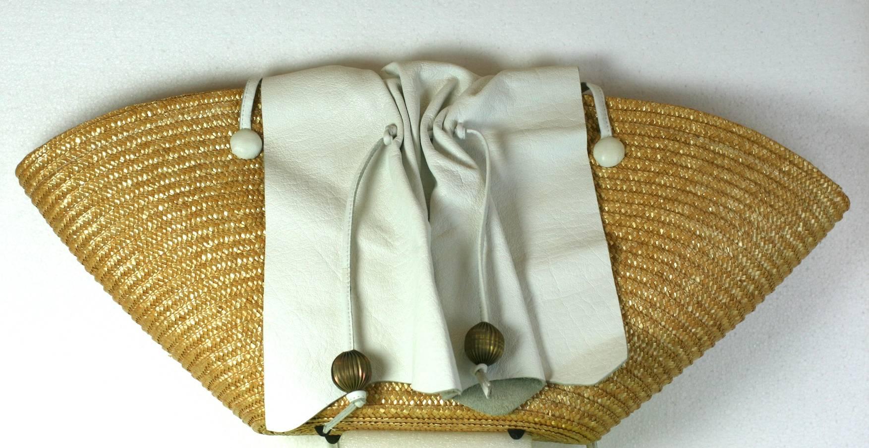 Carlos Falchi Oversized Straw Tote with signature gathered leather flap detail and ribbed ball decoration. Bag is lined in a gold textile with long shoulder straps in white leather. One snap interior closure. Made in Italy. 1980's USA. 
27