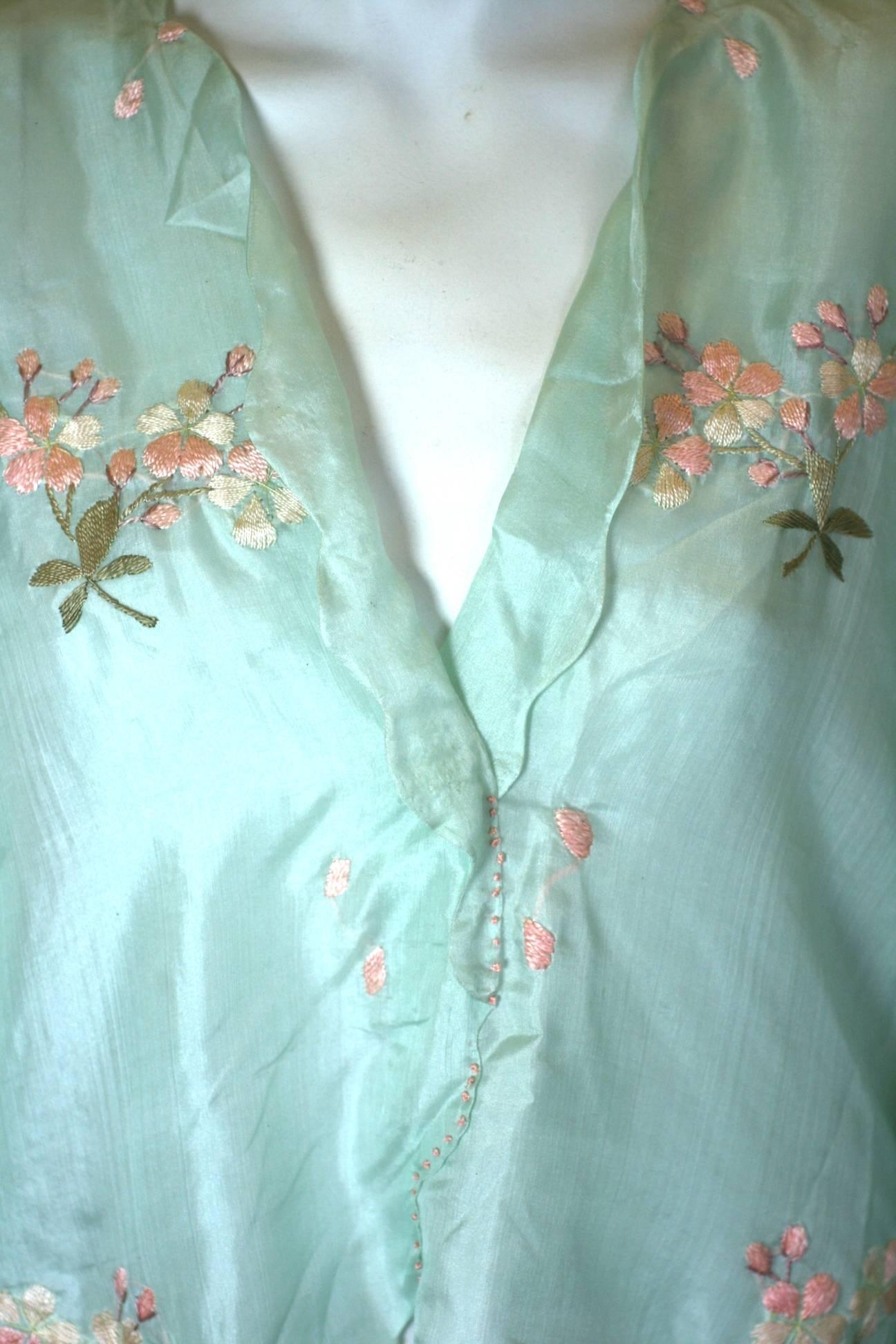 Edwardian china silk blouse of palest robins egg blue, hand embroidered with small bouquets of pink apple blossoms and leaves. Charming scalloped edges with a faux button tab on each side. Completely lined in same silk. Made in Japan for USA export.