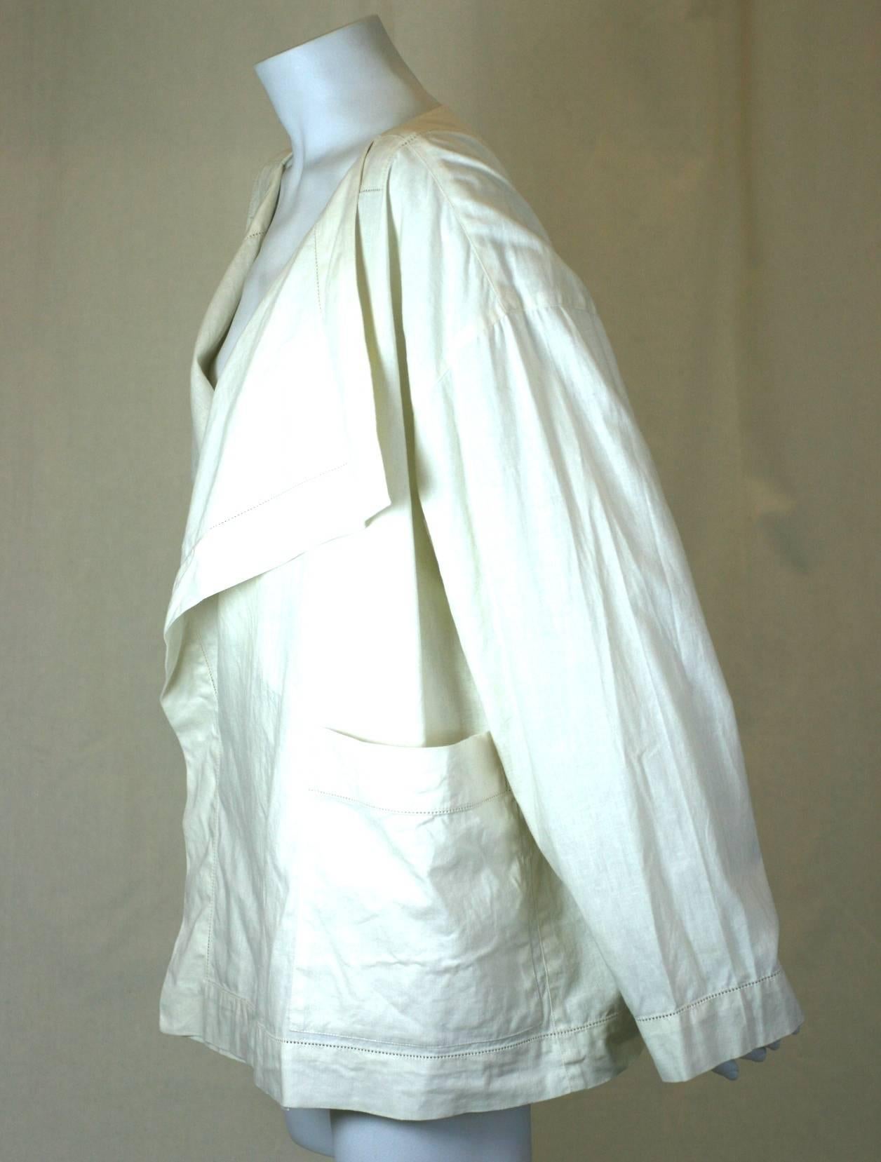 Early Issey Miyake ivory linen jacket cut in a full sized, boxy shape like an oversized T shirt. Large lapels fall from neckline with 2 large patch pockets.
One side button closure. The addition of an interior snap would help to keep the double