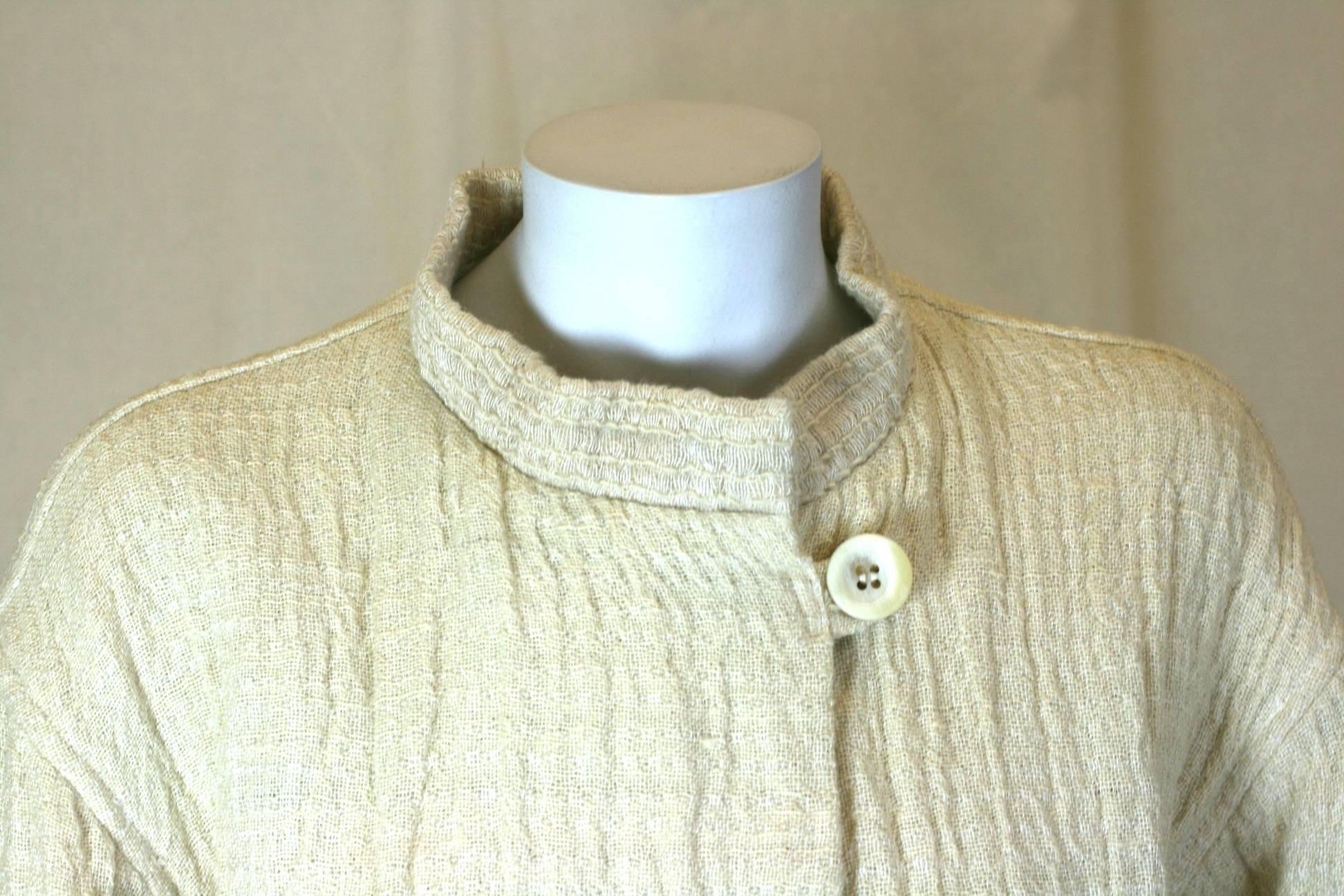 Veste en jute et laine froissée Issey Miyake avec fermeture boutonnée en fausse corne à l'encolure. La fascination de Miyake pour les textiles expérimentaux est évidente dans ce design. Un mélange lourd et froissé de laine, de jute et de lin est