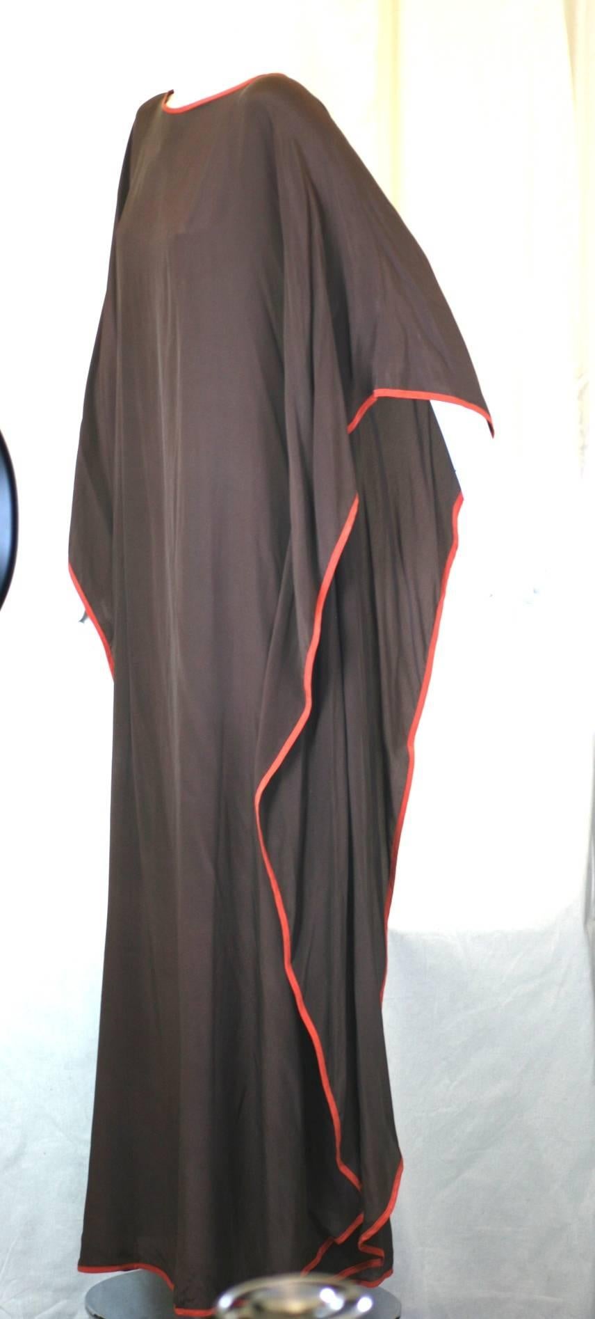 Renata Silk Crepe Caftan in chocolate brown with orange piping. Garment is basically a large rectangle of silk crepe folded in half at shoulder, and tacked at waist on both side seams. Garment is completely open on sides below waist.
Works well
