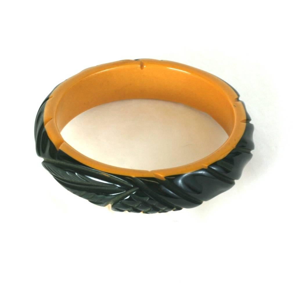 Lovely, collectible 2 toned carved bakelite bangle in black to cream from the 1930's. Leaf carvings with crosshatched designs. Excellent condition. 1930's USA.
