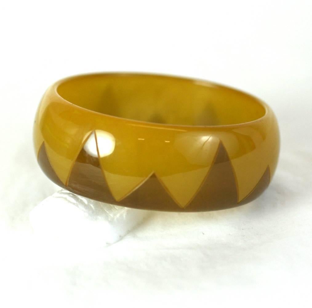 Art Deco Patterned Bakelite Bangle from the 1930's. Unusual lemon syrup yellow toned bakelite with an etched zig zag  Deco motif which has been overstained in darker tone. 1930's USA. Excellent condition. 
1
