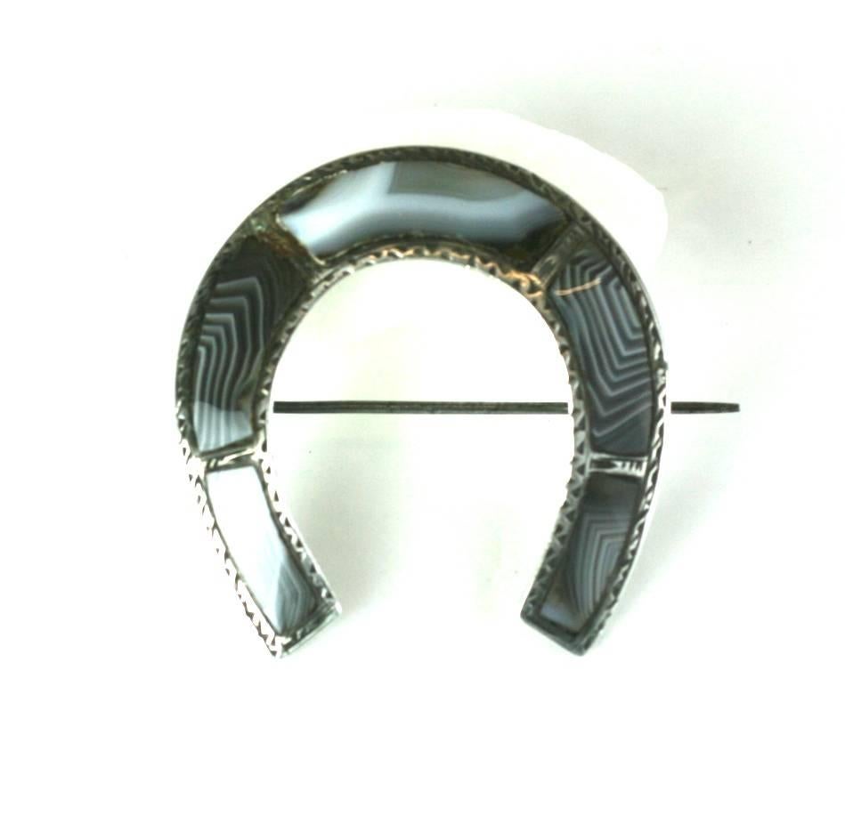 Victorian Scottish Agate Horseshoe Brooch from the mid 19th Century.  Inlaid grey swirled agates are custom cut to the horseshoe form. Set in sterling silver.
1850's UK. Excellent condition.
1 3/4