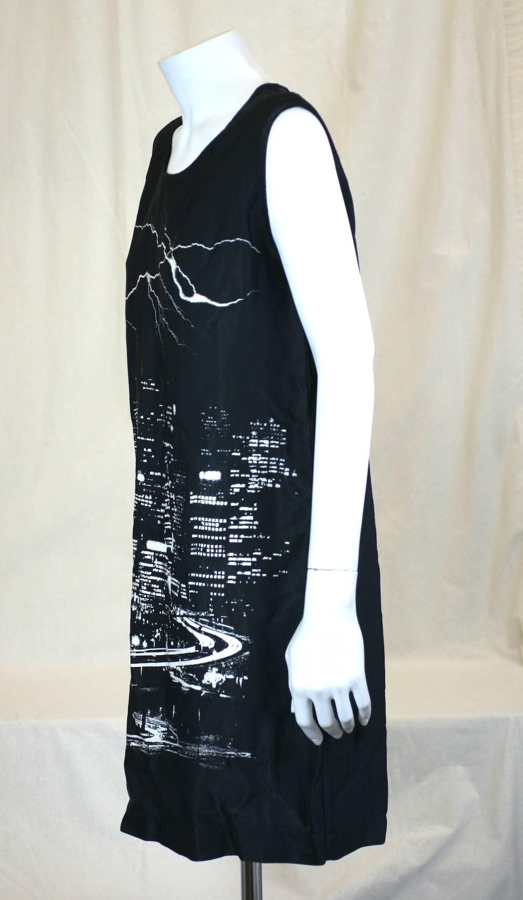 Martin Margiela Lighting Skyline Dress in black rayon/cotton with printed lightening erupting over an urban skyline. 
Simple T shirt lines, from the MM6 line. 1990's France. Size 48. 1990's France.
Length 33", Width 36". Excellent