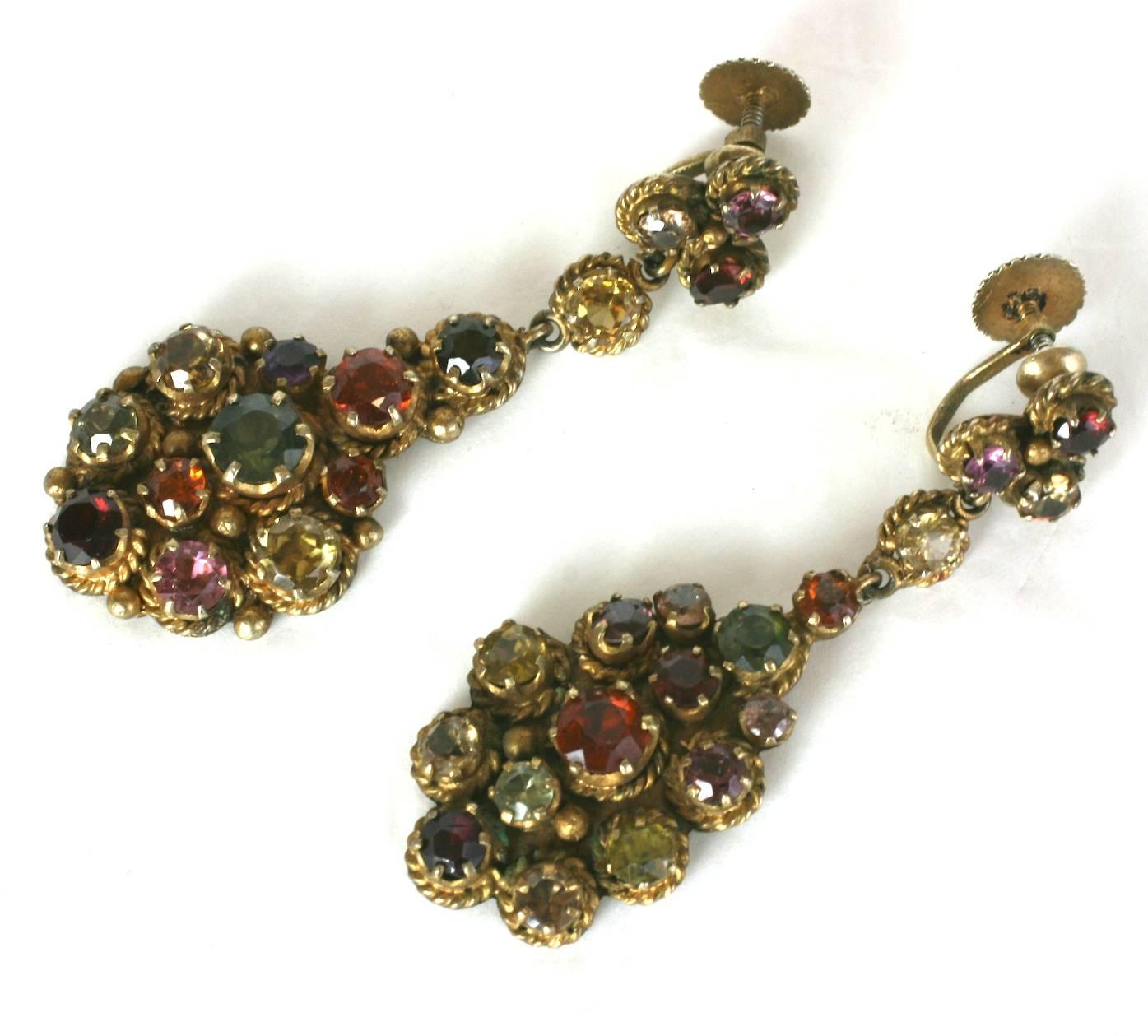 Antique Indian Gemstone Earrings set with a mix of pastes and semi precious stones. Set in gilded silver.
These are not completely symmetrical, as they are hand made. The distinction is small, but, one earring has a bezel around the olivine colored