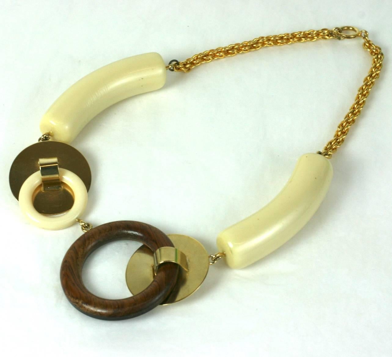 Collier à maillons vari artistique moderniste français composé de disques dorés, de faux bois  et anneaux en bakélite avec de grandes stations de bakélite fausse ivoire à bascule .
Marqué France. Excellent état.
Longueur 18.50