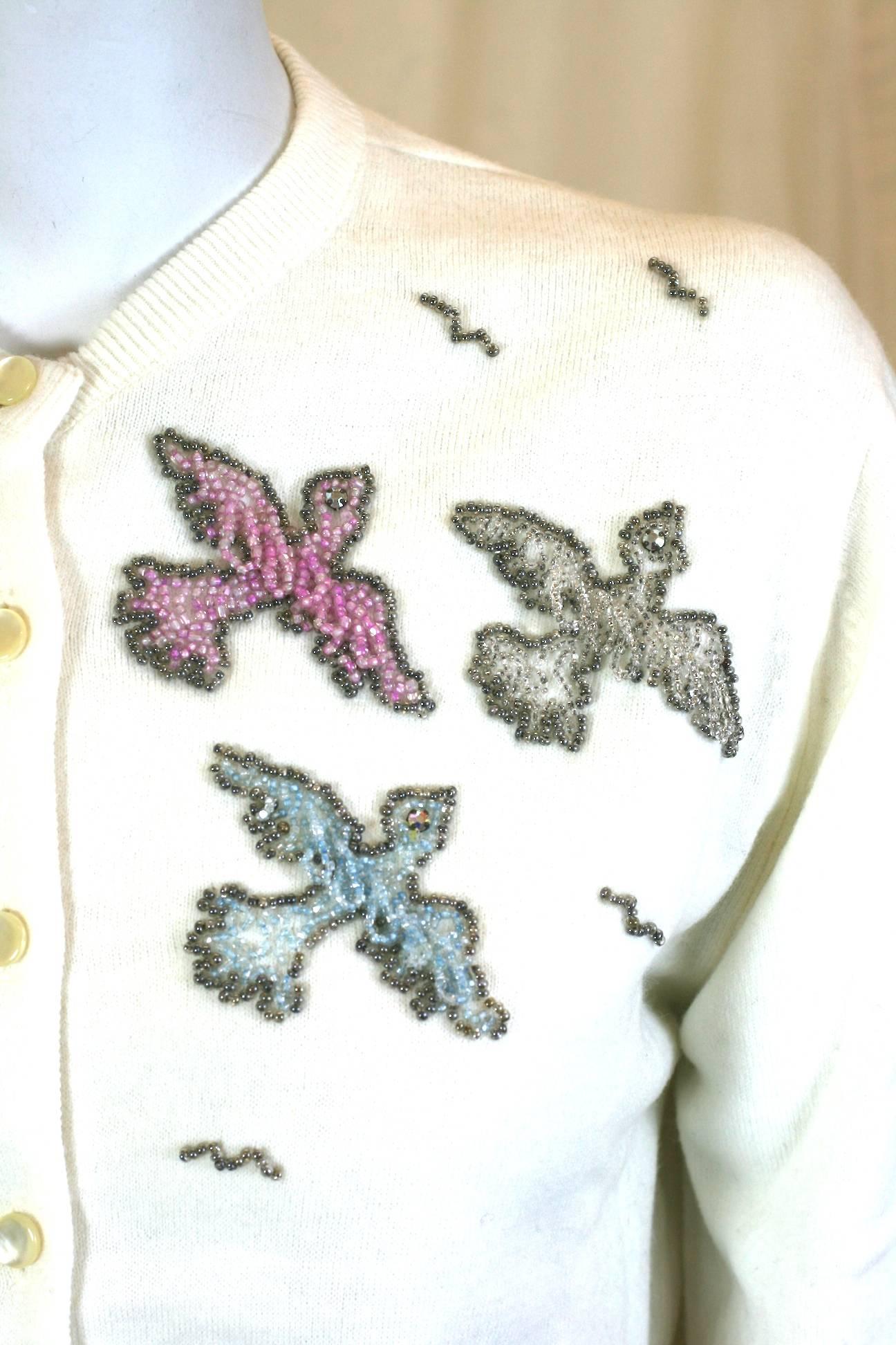Charming cardigan from the 1950's with beaded 3D birds in flight. Birds are hand beaded with looped bead technique for movement and dimension. 
1950's USA. Small size. Orlon knit. 
Excellent condition. 