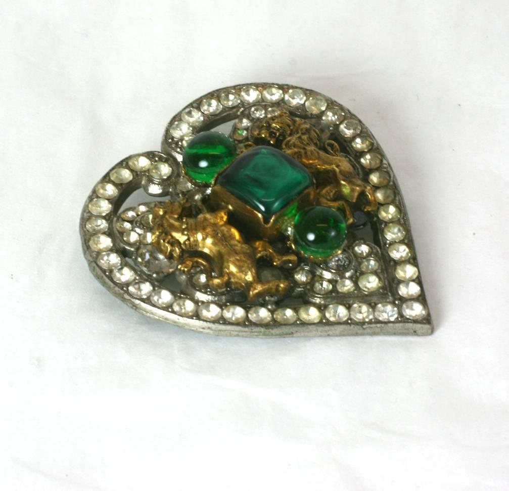 Coco Chanel Early Byzantine heart brooch, The silvered metal heart set with crystal pastes and appliqued with faux emerald hand formed pate de verre rounds and square jelly cut stones. 
Flanked by rearing gilt lion and unicorn, Coco Chanel