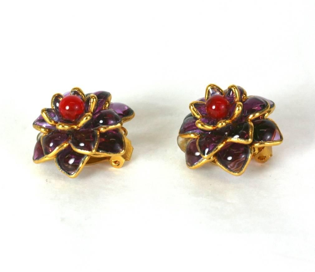 Handmade poured glass Zinnia ear clips made in the French studios of Mark Walsh Leslie Chin. Deep amythest glass is set within gilt metal surrounds. Deep ruby glass bead center. Contemporary.
1.00