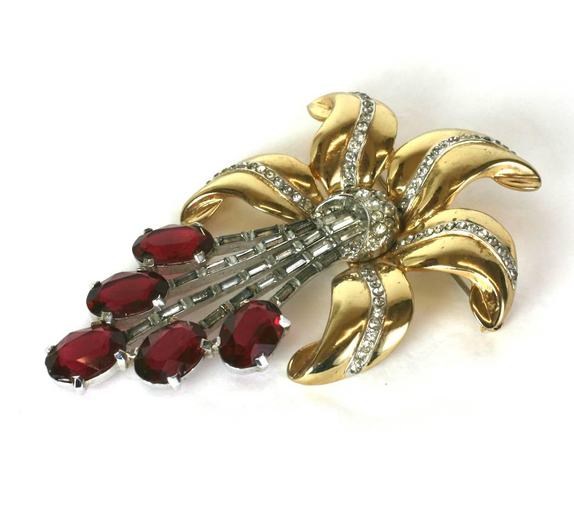 Huge Coro Retro Ruby Lily brooch from the 1940's. Gold toned leaves with pave spines form the petals with the stamen represented by a series of oval faux rubies supported by strips of openwork baguettes. 1940's USA. 
Large and impressive scale,