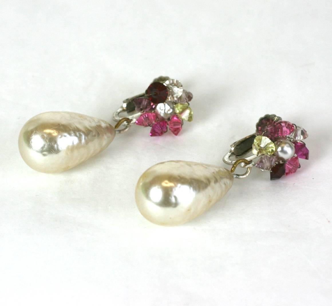 Miiam Haskell signature teardrop baroque pearl and Swarovski hand sewn crystals in varied shades of ruby and pinks, set in silver gilt filigree. Adjustable clip back fittings. 
Excellent Condition. 
Length 1.50