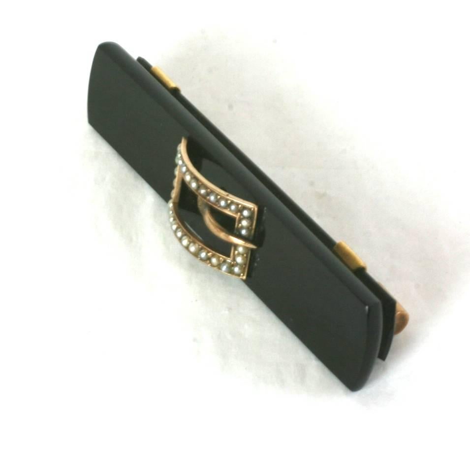 Timeless Victorian Onyx 14 kt Gold and Seed Pearl Buckle Brooch from the late 19th Century. 2.75