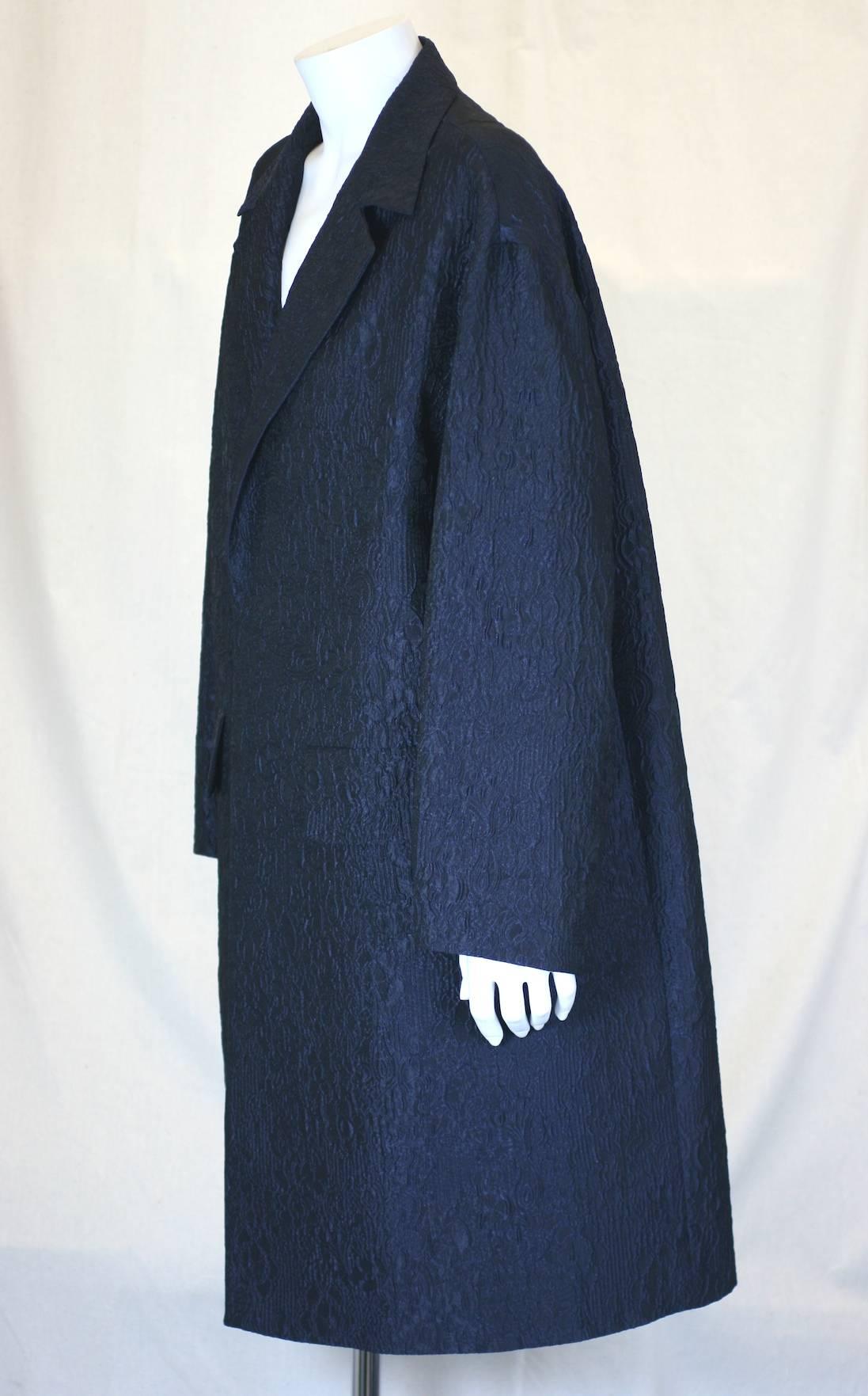 Dries Van Noten Navy Cloque Coat  dress with no closures. Can be simply worn open as an outer piece or belted as a dress. 
Textile is a deep navy iridiscent puckered cloque, very light and crisp. Classic and oversized man tailored coat with drop