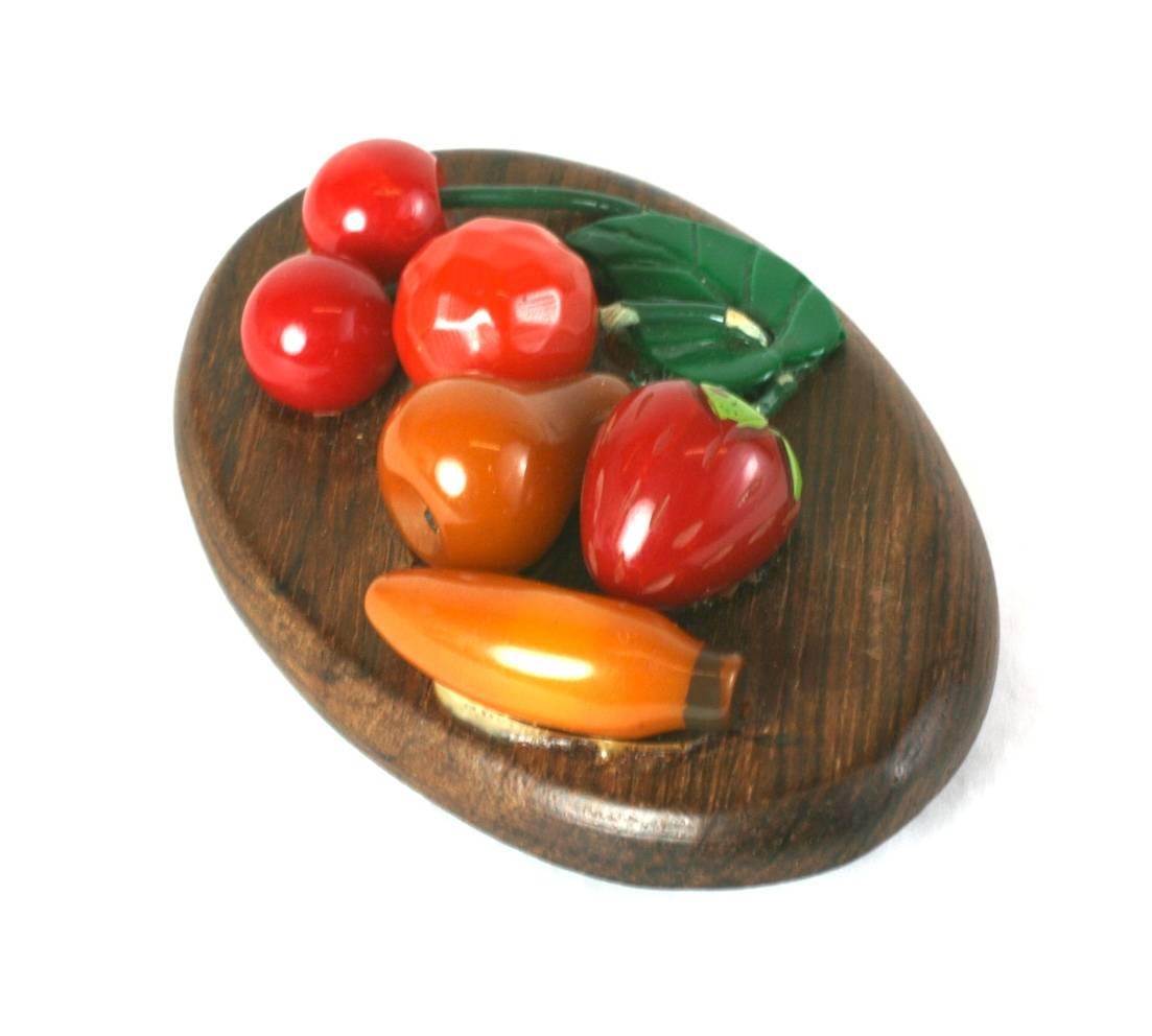 Art Deco Bakelite rare mixed fruit  brooch. The hand carved fruits are applied onto an oval of grained wood,  decorated with laquered green stems and a cellulose acetate molded leaf. 1930's USA. 
Excellent Condition
3