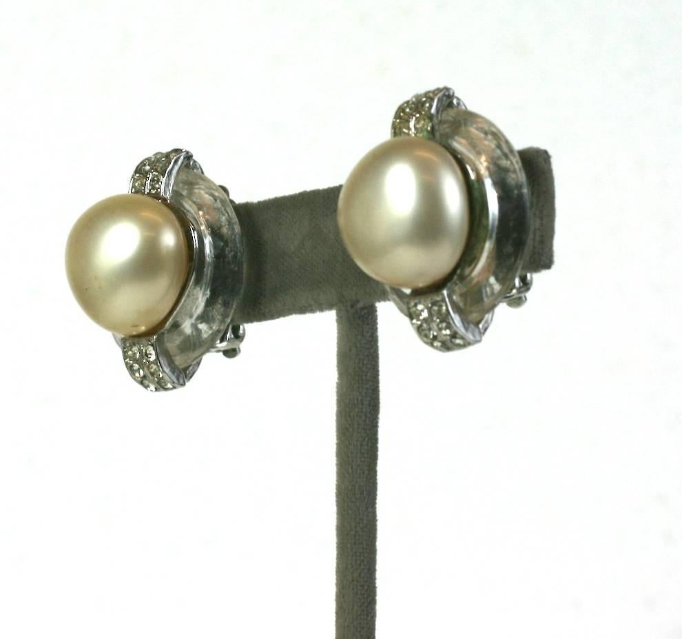 Striking Kenneth Jay Lane Pearl and Crystal Ring Ear Clips from the 1980's. Large faux pearls are set onto crystal rings with pave accents. Clip back fittings. 
1